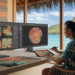 Designer polynésien utilisant l'intelligence artificielle pour créer des visuels modernes dans un studio à Tahiti avec vue sur le lagon